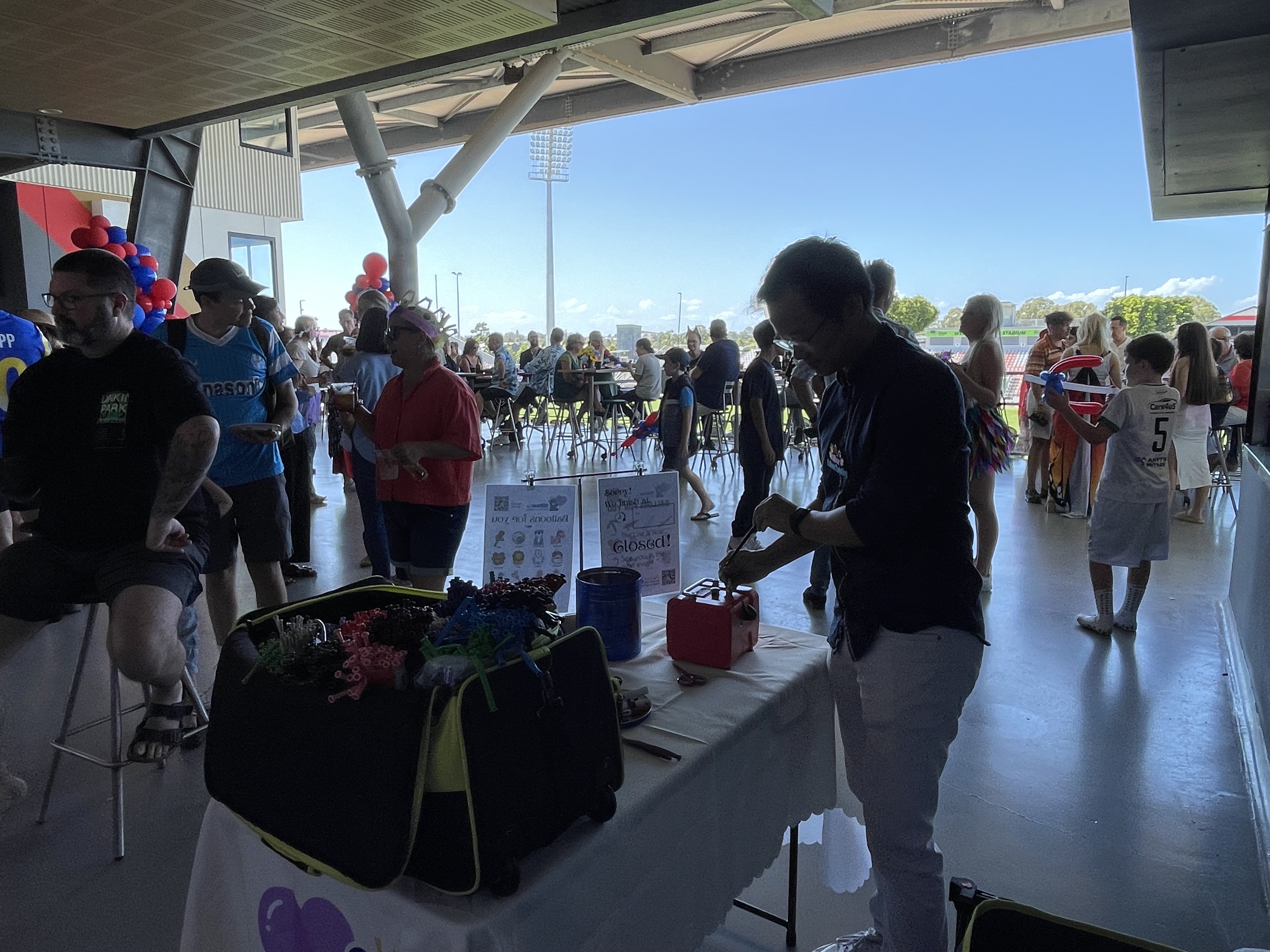 Balloon artist at outdoor stadium community event