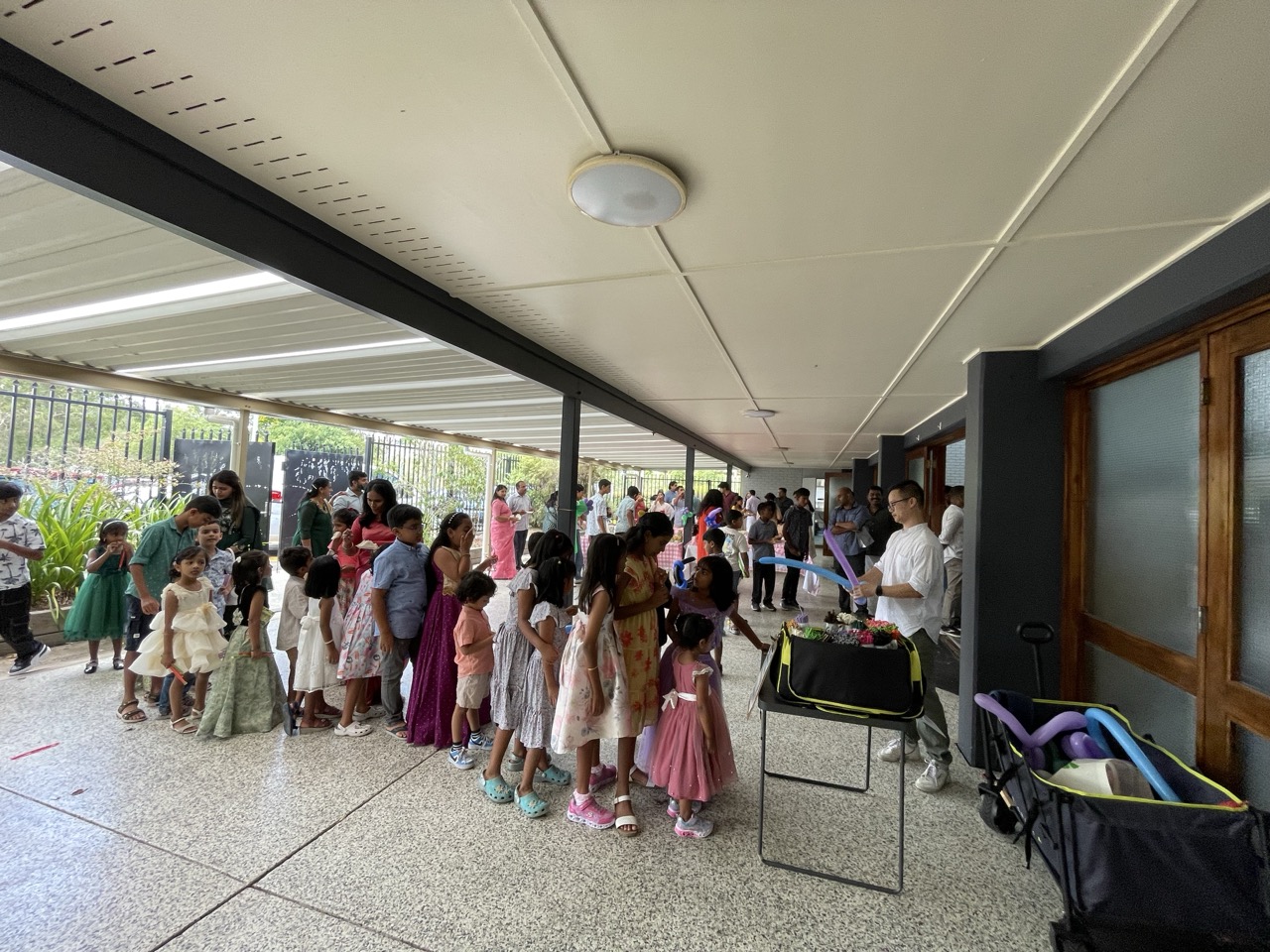 Children lining up excitedly at an outdoor balloon event